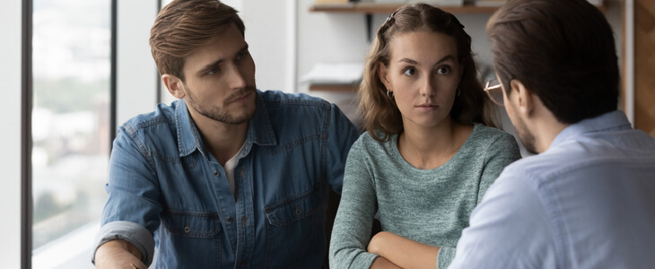 An angry couple confronting their investment advisor on a breach of fiduciary duty