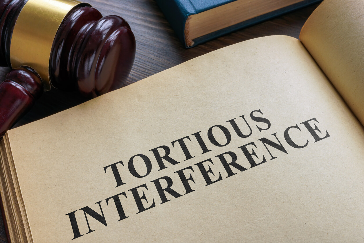 An Open book and gavel. Tortious interference concept.