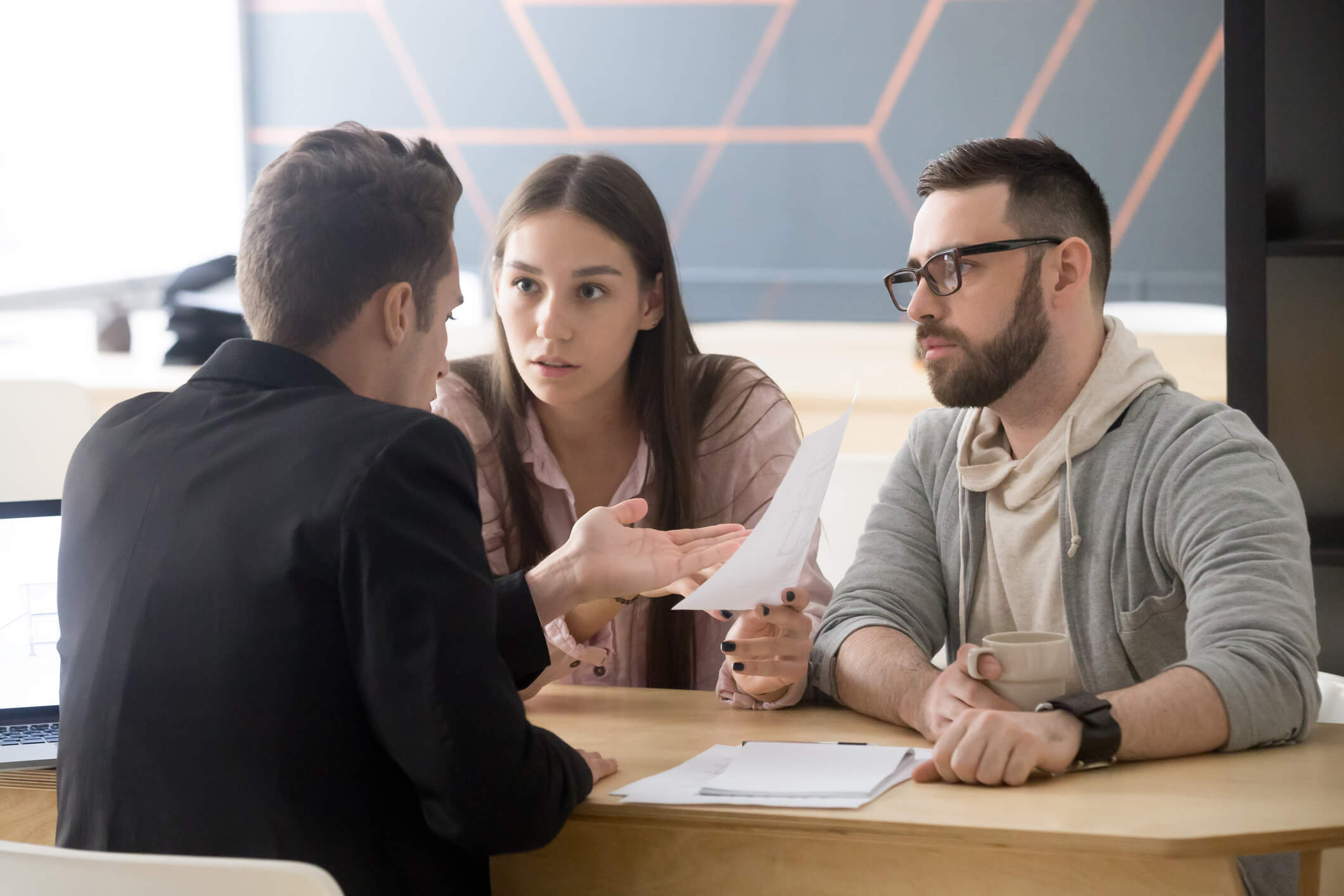 Angry millennial couple complaining having claims about bad contract terms disputing at meeting with lawyer, deceived dissatisfied customers demanding compensation, legal fight and fraud concept
