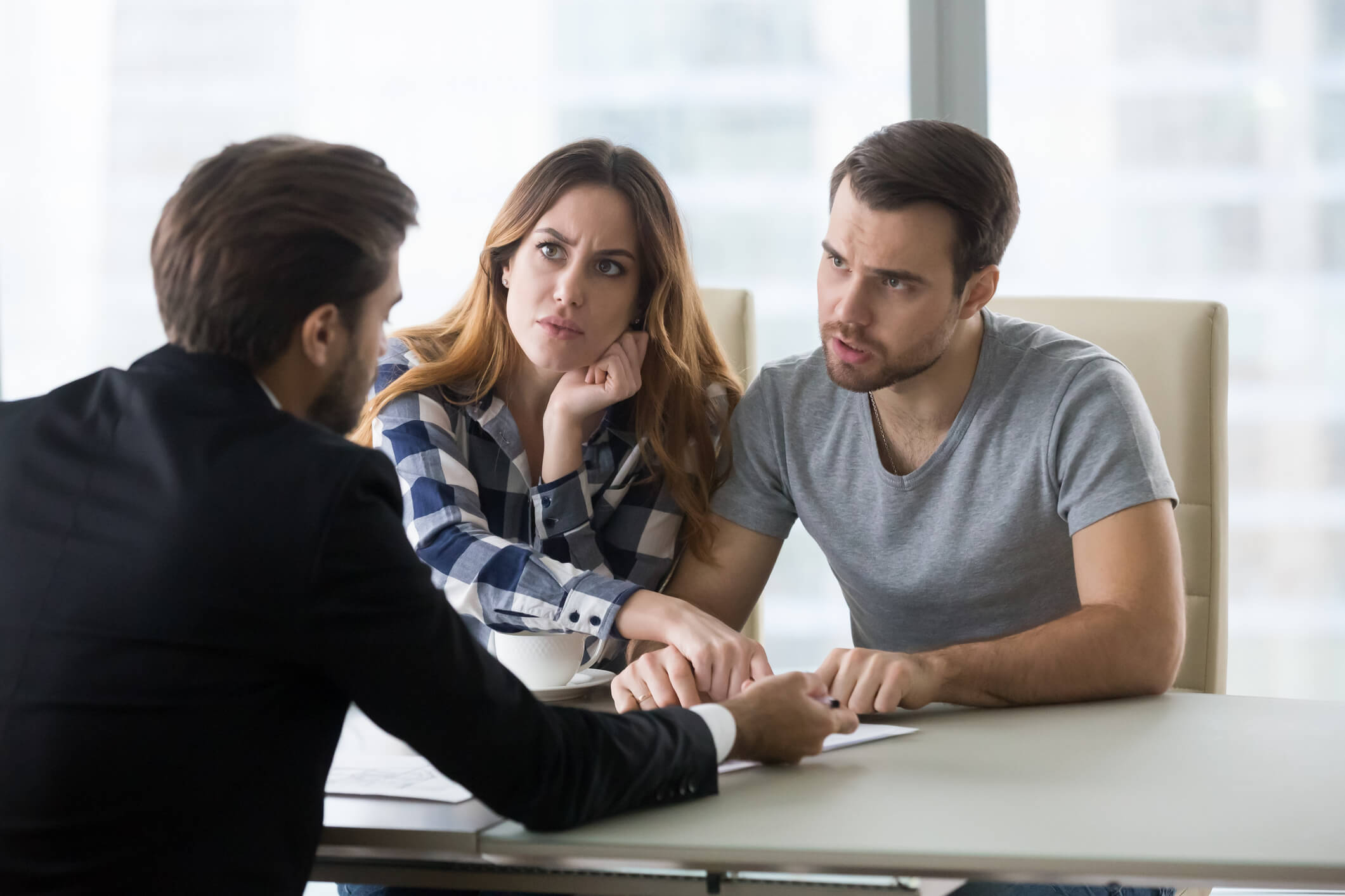Angry dissatisfied couple arguing meeting lawyer or manager having legal fight complaints on bad client service, annoyed mad customers claiming change in contract terms demanding fraud compensation