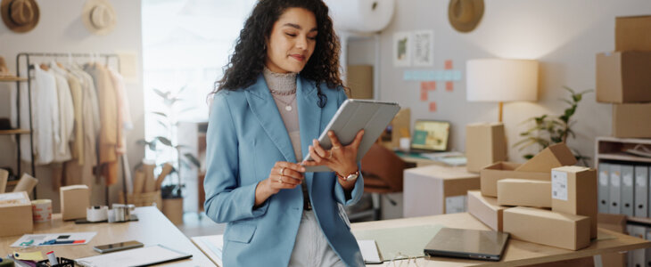small business owner, Business woman, fashion designer and tablet in logistics, research or management at boutique. Female person or entrepreneur working on technology in storage or inventory check at retail store or shop