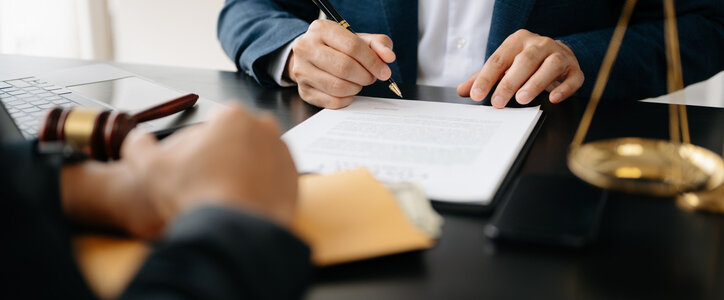 Two lawyers are discussing about contract paper, law matters determination, pointing.law and hammer on the table in office