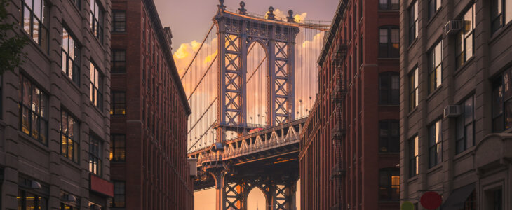 Manhattan bridge seen from a brick buildings in Brooklyn street in perspective, New York, USA. Shot in the evening