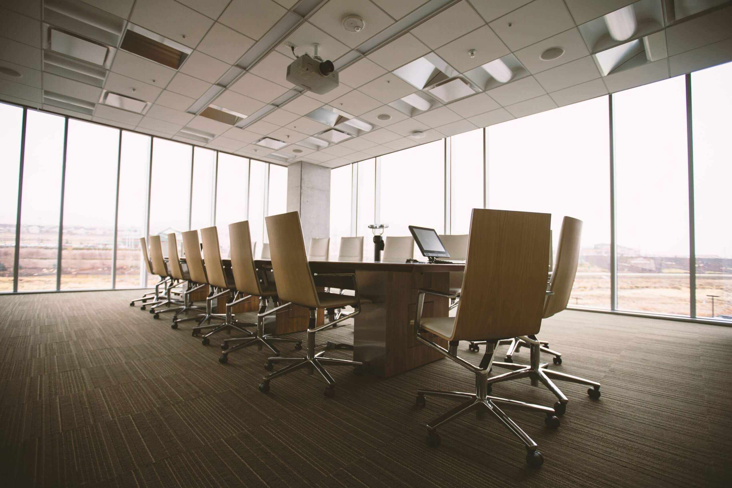 Empty and austere conference room with a long table and chairs