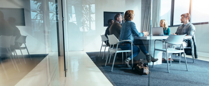 Group of business people sitting in a conference room, discussing and brainstorming over a new project. Creative team of professionals is collaborating on innovative ideas for their company's success.