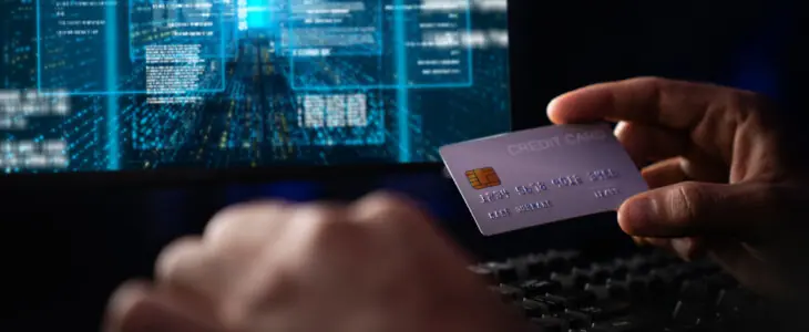 Cropped hands image in criminal anonymous male approaching credit card of personal information database for codding encryption scam program in privacy system at night at blue neon light room. Surmise.